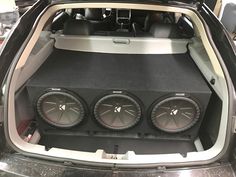 an open car trunk with two subs in the center and four speakers on each side