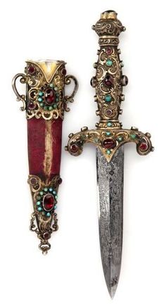 two knives with ornate designs on them are next to each other, one is red and the other is gold