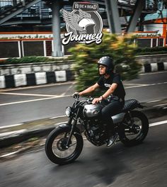 a man riding on the back of a motorcycle down a street