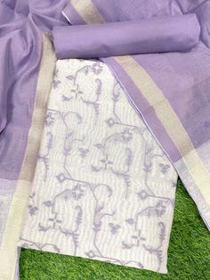 purple and white saree laying on green grass