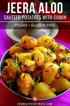 a bowl filled with cooked potatoes on top of a purple table cloth next to a spoon