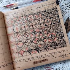 an open book with designs on it sitting on a lace doily covered tablecloth