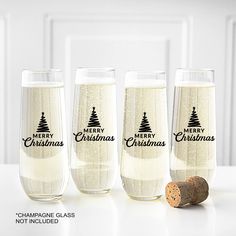 three wine glasses with merry christmas designs on them and a cork in front of them