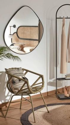 a bedroom with a bed, mirror and hanging clothes rack in the corner next to a chair