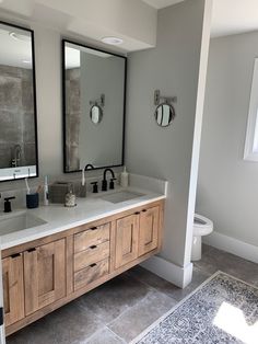 a bathroom with two sinks and mirrors in it