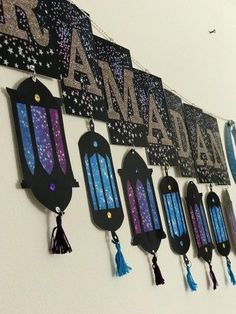 there are many hanging signs on the wall with tassels in front of them