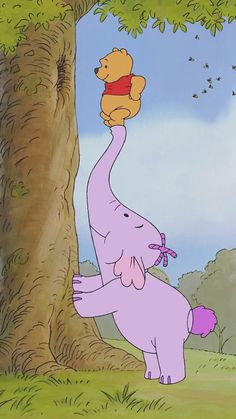 an elephant is reaching up to a tree with winnie the pooh on its back