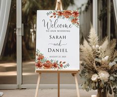 an easel with a welcome sign and flowers