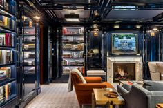 a living room filled with lots of furniture and bookshelves covered in shelves next to a fire place