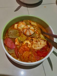 a bowl filled with soup and vegetables on top of a table