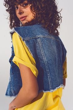 Edgy and stylish, our Cropped Studded Denim Vest in Blue is a must-have for the fashion-forward individual. Crafted with 100% cotton, this vest features a standard fit that runs true to size, modelled by our petite model with measurements 31-22-34 and a height of 5 feet, wearing a size S. The design is elevated by the studded embellishments that add a unique touch to the classic denim vest. The cropped length, frayed ends, and chest pockets combine fashion with functionality. The vest is finishe Spring Medium Wash Denim Vest, Trendy Blue Denim Vest Top, Dark Wash Short Sleeve Denim Jacket For Spring, Blue Denim Vest Top For Spring, Short Sleeve Dark Wash Denim Jacket For Spring, Spring Dark Wash Denim Jacket With Short Sleeves, Denim Vest With Pockets, Short Sleeve Denim Vest With Pockets, Denim Blue Denim Vest Outerwear