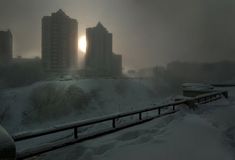 the sun shines brightly through the foggy sky over snow - covered hills and buildings