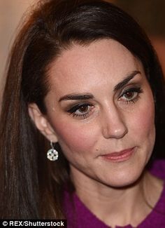 a close up of a person wearing a purple coat and some earrings on her head