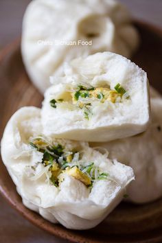 steamed dumplings with herbs and cheese in a wooden bowl on top of a table