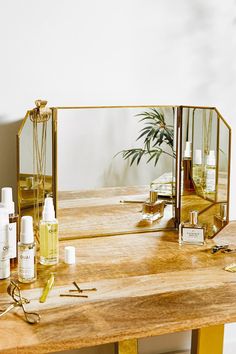 a mirror sitting on top of a wooden table next to a bottle of lotion