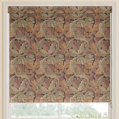 a window with a brown and tan patterned roman blind