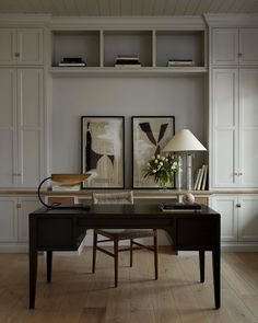 a home office with two framed pictures on the wall