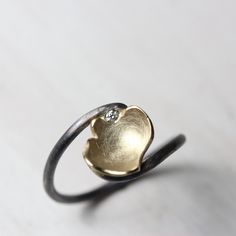 Cup of Luck is an adorably romantic diamond ring. If you are into symbolism and could use a lucky streak this might be for you! Subtle yet striking it was handmade from sterling silver and 14k yellow gold. The chalice shaped flower petal contains one flush set 1.5mm diamond (G color, VS quality). The cup measures 10-11mm in diameter. Size 6.5 or 53.5 or 17 or M 1/2 nangijalajewelry.etsy.com One Of A Kind *Please note: The deep black oxidation will wear off over time. You are welcome to send your Silver Jewelry With Single Diamond For Proposal, Silver Diamond Jewelry For Proposal, Flower-shaped Diamond Ring With Accents As Gift, Flower Shaped Diamond Ring With Accents For Gift, Gold Flower Ring For Proposal, Flower Shaped Diamond Ring With Accents, Flower Shaped Diamond Ring With Diamond Accents, Heirloom Flower Ring With Brilliant Cut For Gift, Heirloom Style Flower Ring With Brilliant Cut For Gifts