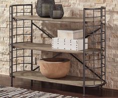 three tiered shelving unit in front of brick wall