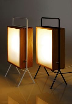 two lamps sitting next to each other on top of a white floor covered in light