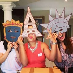 three women holding up masks in front of their faces