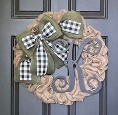 a monogrammed wreath on the front door is decorated with scissors and burlocks