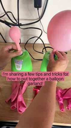 two hands holding pink and green balloons on top of a wooden table with text that reads, i'm sharing a few tips and tricks for how to put together a balloon garland