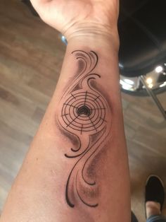 a person's arm with a tattoo on it and a spiral design in the middle