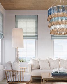 a living room with two couches and a chandelier hanging from the ceiling