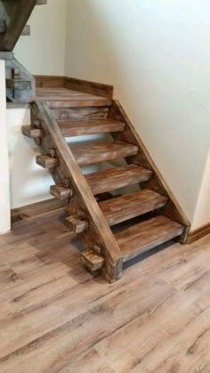 a wooden stair case sitting on top of a hard wood floor