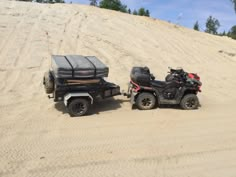 two atvs parked in the sand on a sunny day