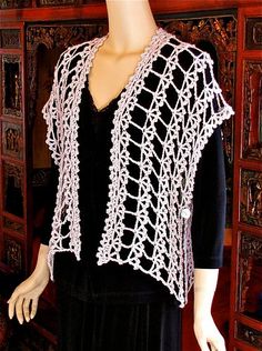 a mannequin wearing a black dress and white crochet shawl