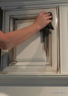 a person is cleaning the inside of a cabinet door