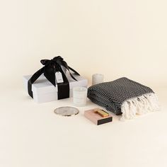 a black and white gift box, candle, soap, napkin, and other items