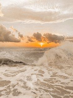 the sun is setting over the ocean with waves crashing in front of it and an orange sky