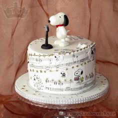 a cake decorated with musical notes and a snoopy dog sitting on top of it