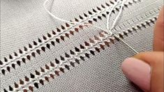 someone is stitching the thread on a white piece of fabric