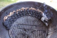 a charcoal grill with rocks and wood on it