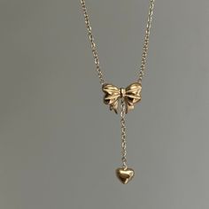 "Bow Drop Heart Necklace  ✨ Fully stainless steel & tarnish proof! (18k gold plated) 15.5\" with a 2\" extender  oval link chain style featuring a unique mini gold puffed bow pendant & mini heart pendant 🤍 Handmade with love!" K Jewelry, Jewelry Accessories Gold, Cute Heart Necklace, Jelewry Gold, Gold Necklace With Heart Pendant, Pretty Jewellery Gold, T Necklace, Dainty Jewellery, Heart Shaped Locket