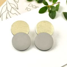 Double circle stud earrings made from real leather. Minimalistic geometric form jewelry for everyday use. Lightweight circle stud earrings from gray and gold leather discs to make every day special. This is a handmade leather accessory with acrylic painted edges. Materials: leather, stainless steel, rubber, and iron earring backs, acrylic paint Color: Gray and Gold Length: 1.58 in / 4 cm  Width: 0.98 in / 2.5 cm *Made with 100% genuine leather *Handmade *Minimalist accessory Dare to DREAM! It is Boho Leather Jewelry, Leather Stud Earrings, Leather Accessories Handmade, Colorful Paintings Acrylic, Festival Earrings, Gray Earrings, Minimalist Accessories, Geometric Studs, Circle Earrings Studs