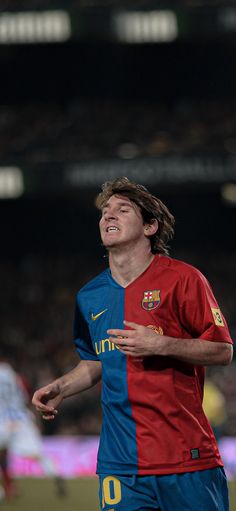 a soccer player is smiling and looking up at the sky with his hands in his pockets