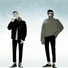 two men standing next to each other with snow falling all over their heads and hands on their chins