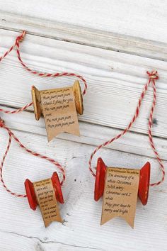 three small red bells with paper tags attached to them