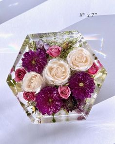 a glass vase filled with flowers on top of a table