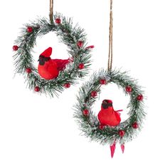 two christmas wreaths with red birds hanging from them