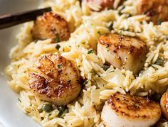 some scallops and rice on a white plate