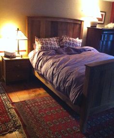 a bed sitting in the middle of a bedroom next to two lamps on either side of it