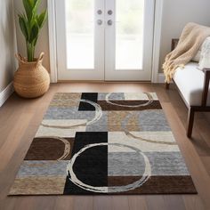 a living room area with a rug, chair and potted plant