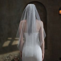 the back of a bride's dress with a veil on her head