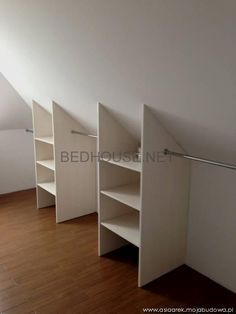 an empty room with white closets and shelves in the corner, on top of a hard wood floor